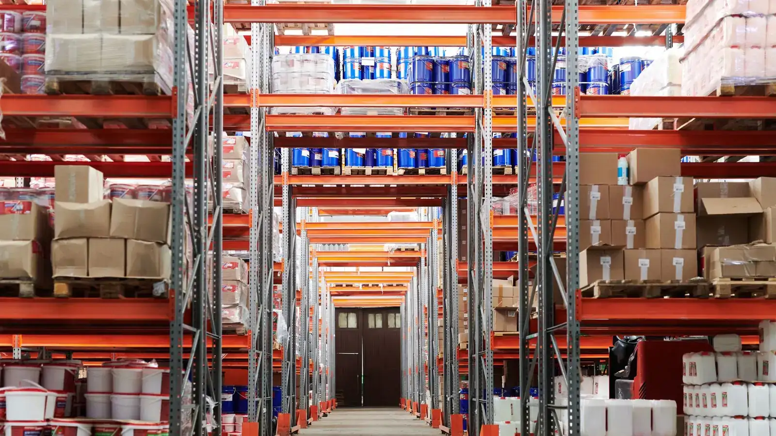 Warehouse aisle with steel racks holding boxes and pallets