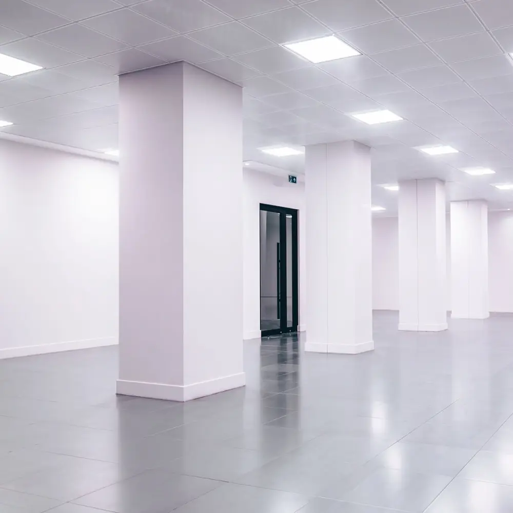 Empty white office space with columns and ceiling lights